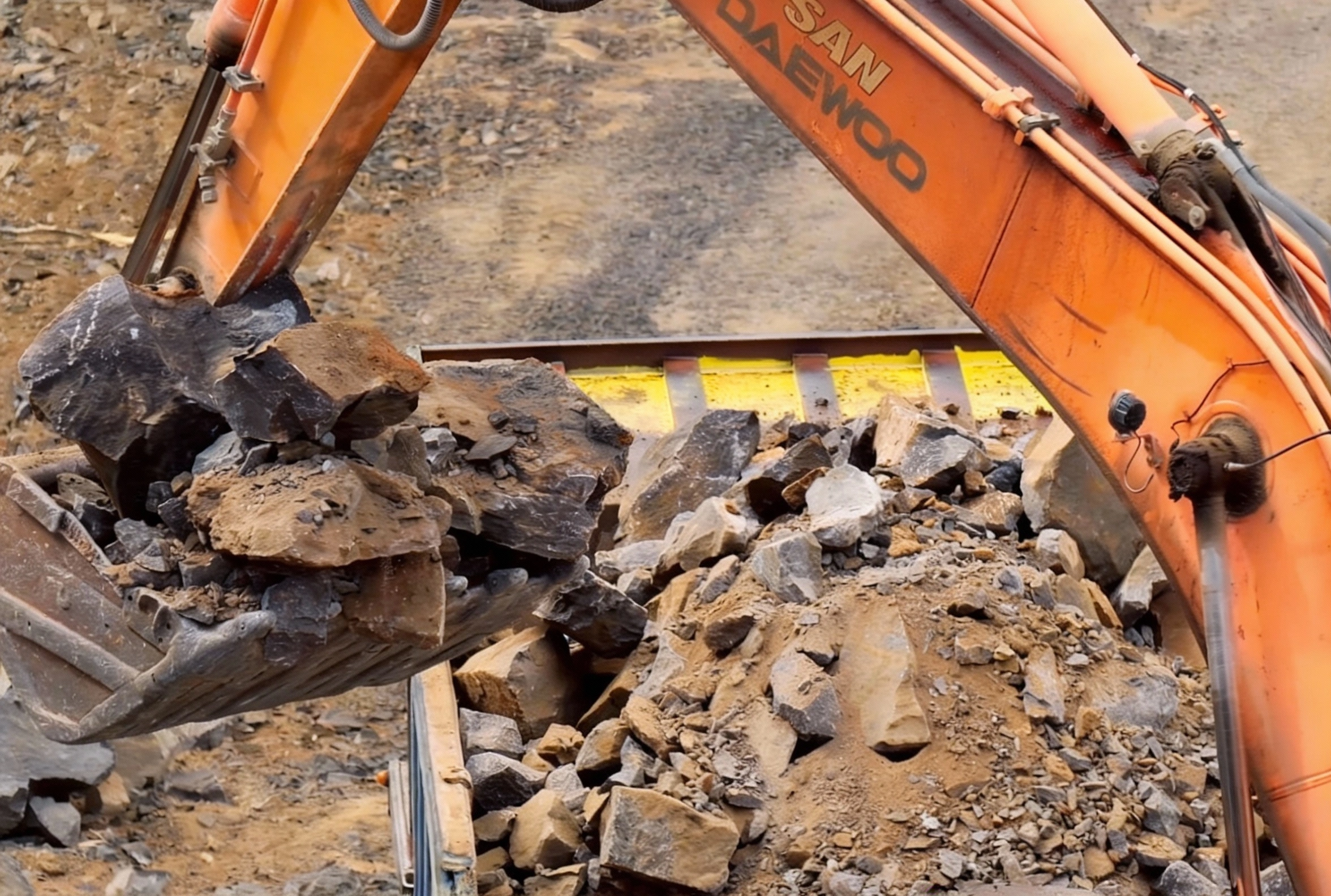 Excavator handling rocks and debris during professional excavation work on Los Angeles construction site