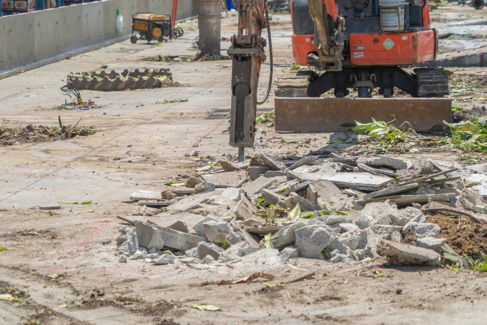 Concrete breaking and demolition work using excavator-mounted hydraulic hammer in Los Angeles