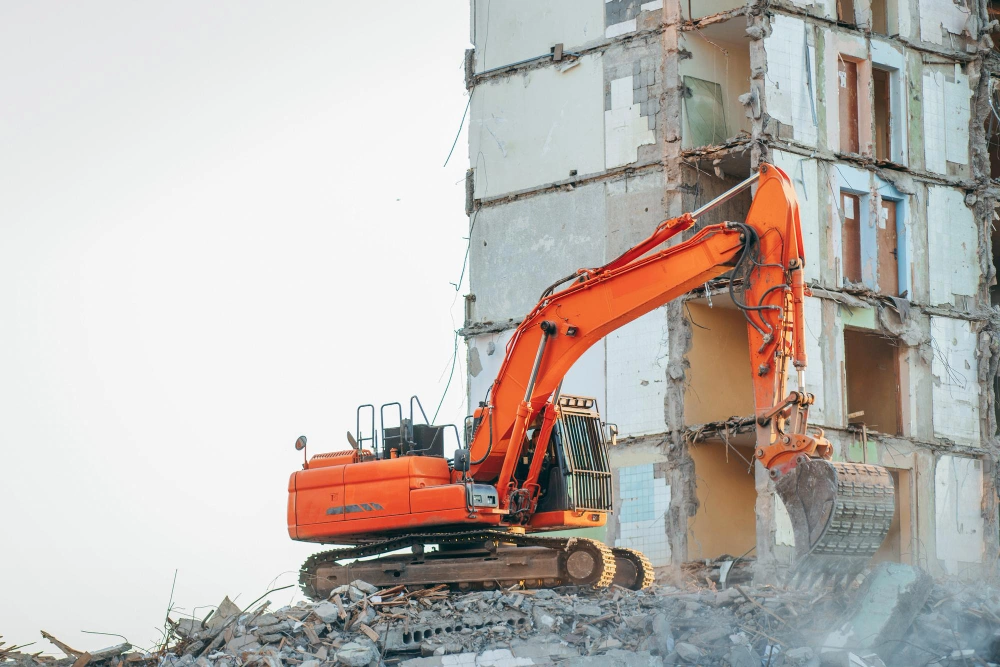 Excavator tearing down concrete structure during professional demolition work in Los Angeles