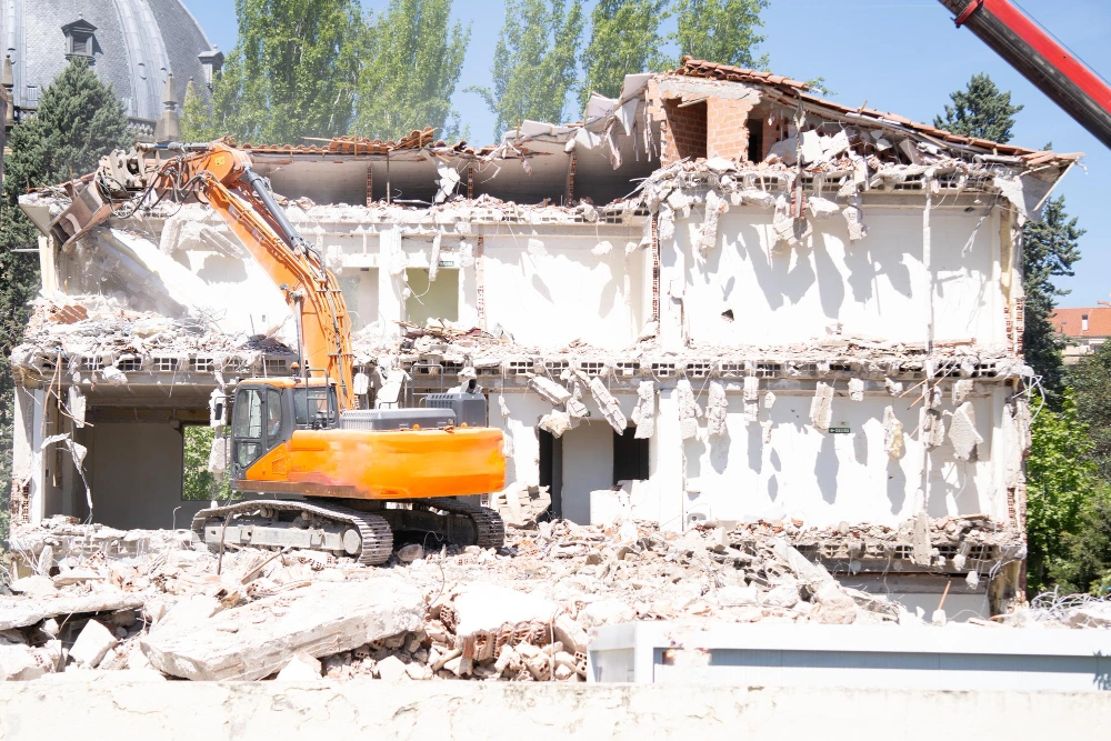 Controlled demolition of commercial property with excavator removing debris in Los Angeles